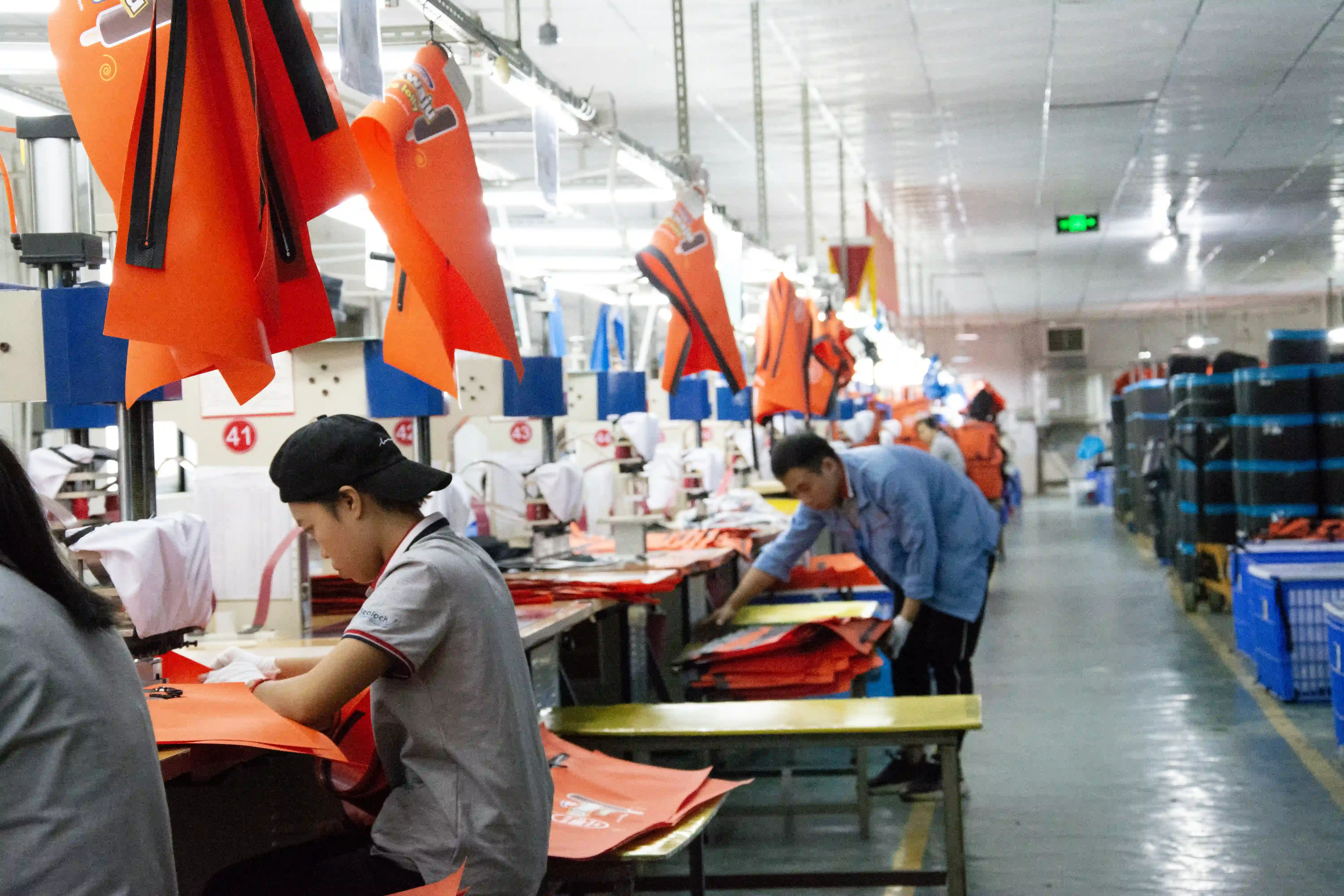 Massive OEM outdoor gear manufacturer facility floor featuring advanced RF welding machines and automated TPU lamination lines for high-volume waterproof equipment production.